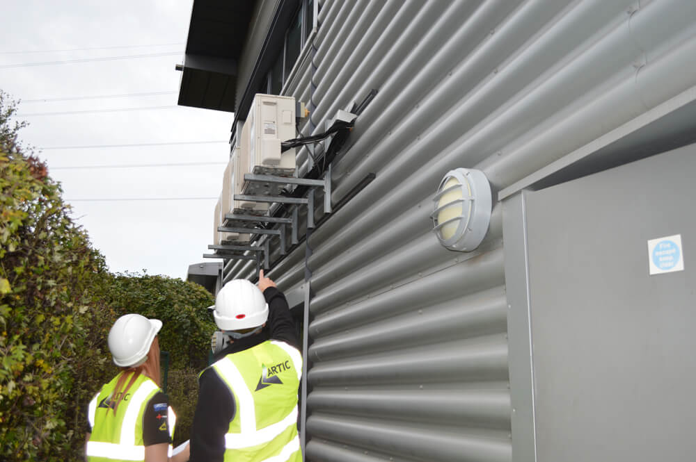 2 engineers looking at HVAC system